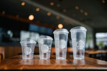Starbucks cold cups in various sizes with lids in a line