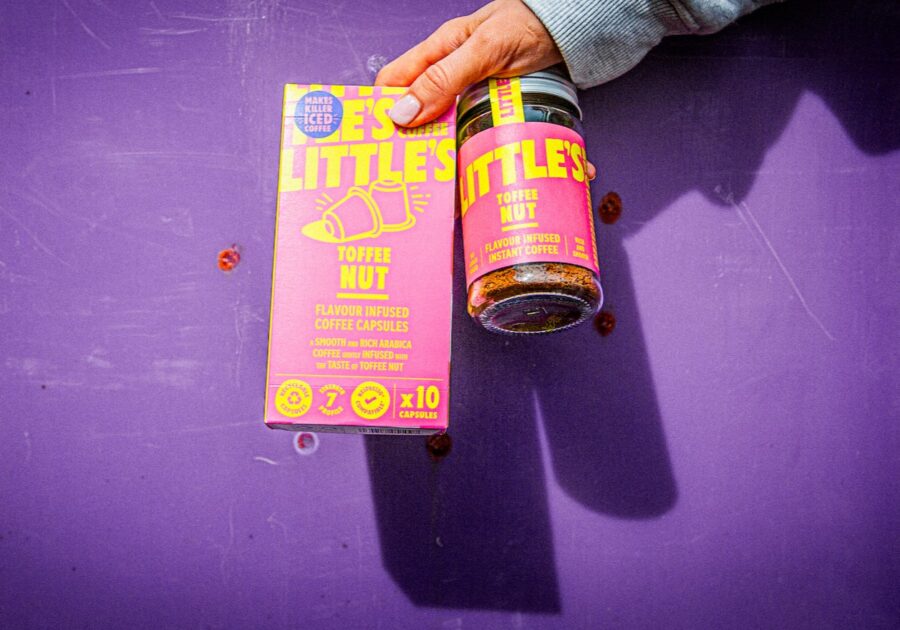 Little's Toffee Nut capsules and instant coffee products held up against purple background.